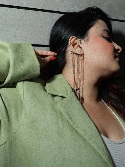 A close-up focusing on the model's profile and the long, dangling ear cuff, highlighting how accessories complete an outfit.