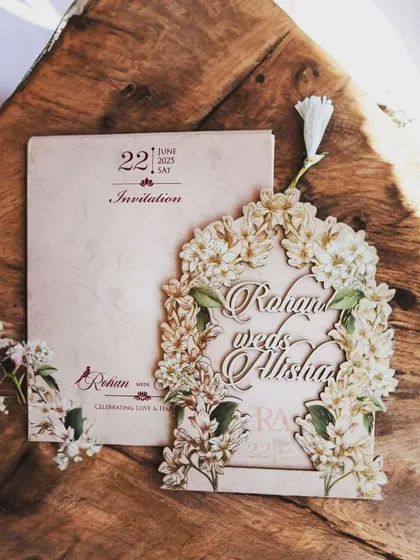 This arch-shaped laser-cut invitation is adorned with white flowers, creating a romantic and ethereal gate to your wedding details.