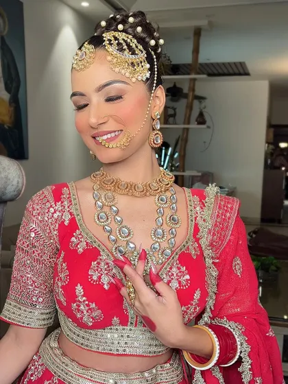 A candid, happy moment of a bride in her red lehenga, capturing the essence of her special day.