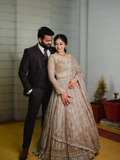 A full-length portrait of the couple. The bride's makeup and hairstyle complete her elegant reception look.