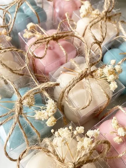These mini bubble candles, or "mini bubs," are an adorable and elegant favor for a baby shower, tied with rustic twine and dried flowers.