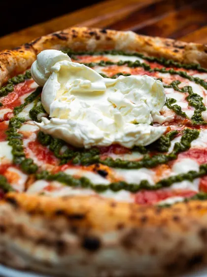 Some serious pizza making happening right here. This is our Burrata Pesto pizza.