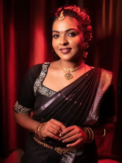A model posing in a black saree, with dramatic lighting that highlights her features.