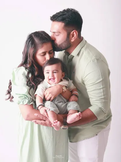 Pure bliss. The smiles on their faces say it all as they cuddle their little one. This is a classic family portrait that radiates warmth and happiness.