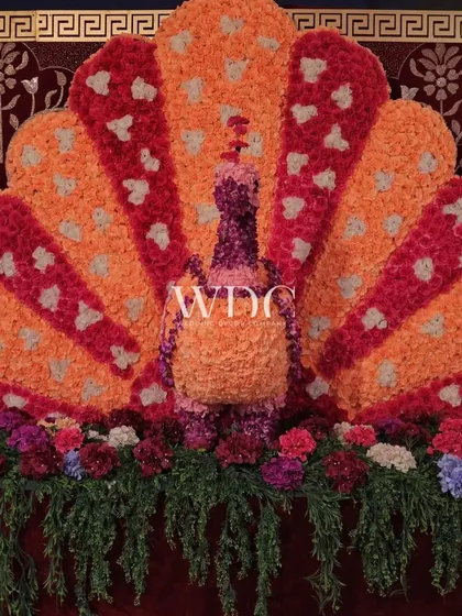 A magnificent peacock made entirely of orange and red flowers, showcasing our team's artistry and attention to detail in creating unique floral sculptures.