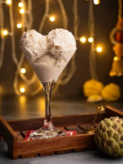 A modern twist on a Diwali dessert. We served Sitaphal ice cream in a fancy glass against a backdrop of festive lights, blending tradition with contemporary style.