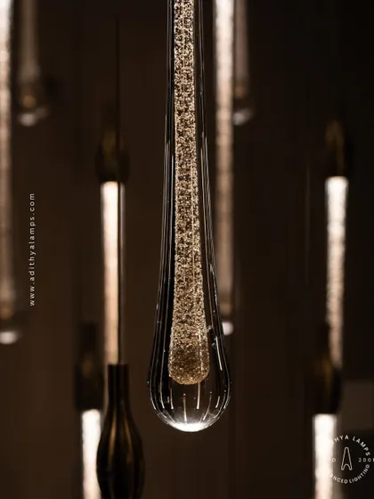 A stunning cluster of crystal teardrop pendants. Each pendant contains bubble-like inclusions that catch the light, creating a sparkling, rain-like effect. This is an elegant choice for double-height foyers or modern staircases.