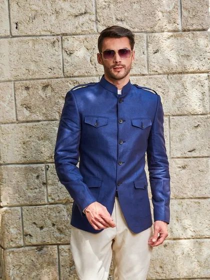The sheen of the Irish linen in this cobalt blue jacket is captivating. The epaulets and four-pocket design give it a distinguished, almost military-inspired sharpness.