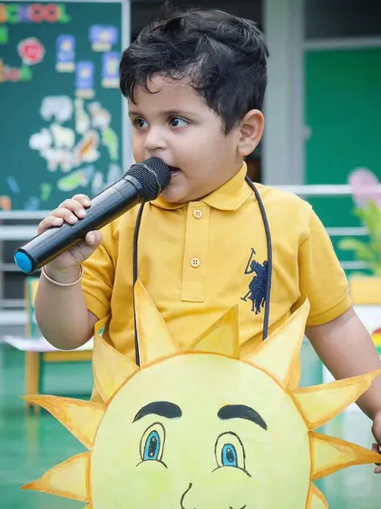Every child is a performer at heart. This shot from a school event captures a young boy confidently taking the stage in his sun costume, a memory his parents will treasure.