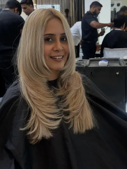 A happy client showing off her new straight and sleek blonde layers. The cut and color work together for a truly glamorous result.