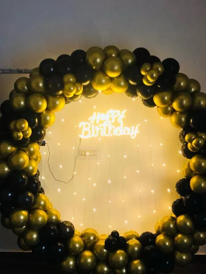 A clean shot of the black and gold balloon ring with the neon sign and fairy lights, showing the core backdrop before props are added.