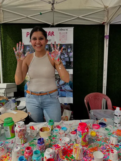 Me, with my paint-splattered hands, at our flea market stall. I love getting just as messy as the participants. It’s all part of the fun.