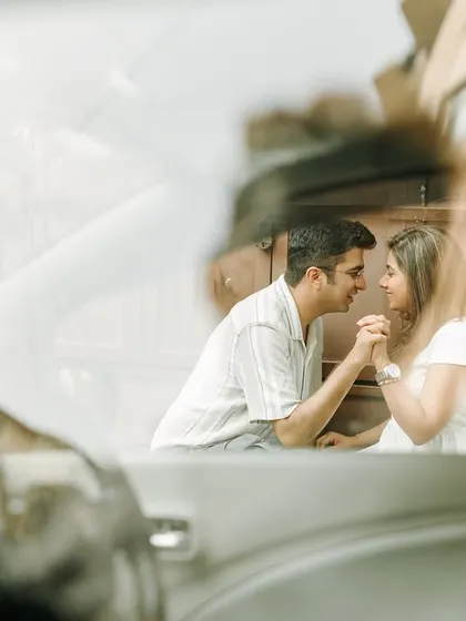 A unique pre-wedding shot through a car window, capturing an intimate moment between the couple.