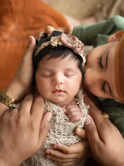 A tender moment as a big brother gently kisses his newborn sister's cheek. Sibling photoshoots, especially with a new baby, are so precious for capturing the start of a lifelong bond.