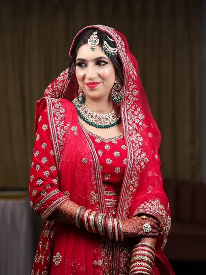 My beautiful bride Sidra, glowing for her Nikah. This look features a classic red lip and soft eyes, paired with green jewelry for a timeless combination.