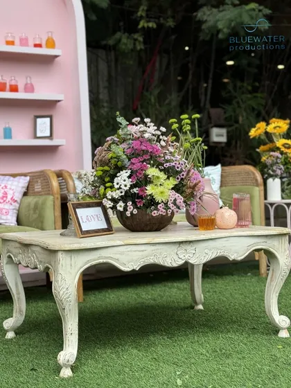 A beautiful vintage-style table serves as the centerpiece of the lounge area.