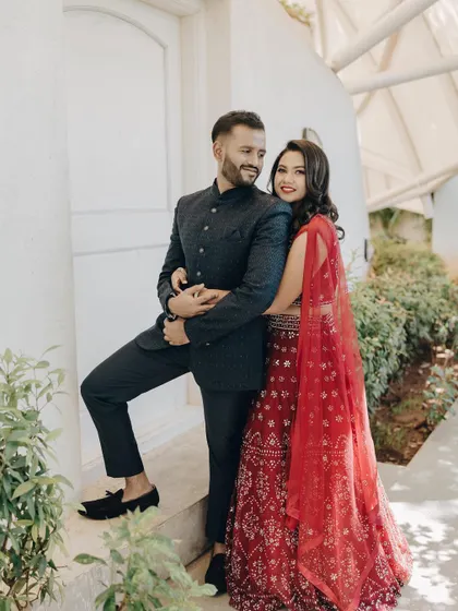 A lovely couple's portrait. The bride's red lehenga and the groom's classic bandhgala create a perfectly coordinated and stylish look.