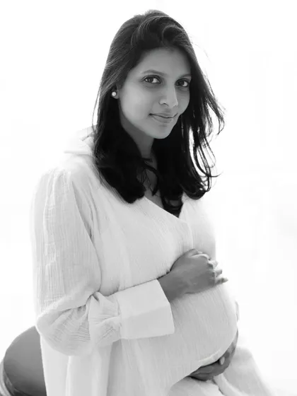 A simple, clean, and beautiful black and white portrait. The direct gaze and gentle smile create a powerful and intimate connection with the viewer.