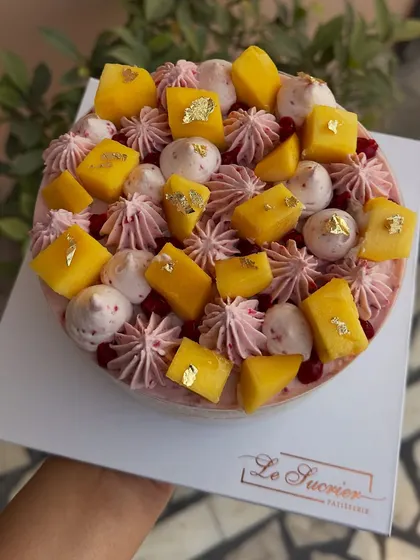A beautiful love triangle of mango, raspberry, and cake. This creation is topped with fresh mango chunks, meringue kisses, and a hint of raspberry.