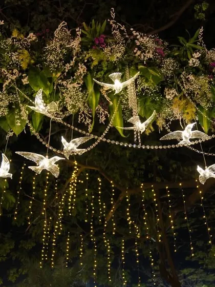 A beautiful shot of the hanging crystal bird decorations, intertwined with fresh flowers and fairy lights. This detail added a layer of sparkle and sophistication to the anniversary decor.