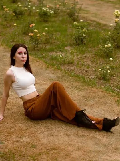 An outdoor portrait of a model seated in a field of flowers. Using natural environments adds a soft, organic feel to a portfolio, perfect for lifestyle or bohemian-themed brands.