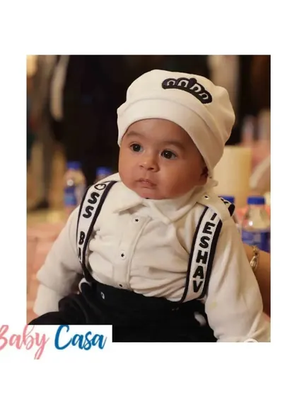 This little boss is ready for his close up. Dressed in a "Boss Baby" romper with personalized suspenders and a matching cap, he looks absolutely adorable and full of personality.