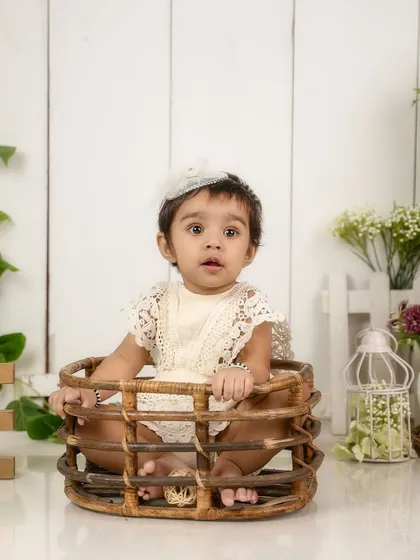 A full view of the rustic basket pose. This is a classic and safe way to photograph a baby who is confidently sitting up.