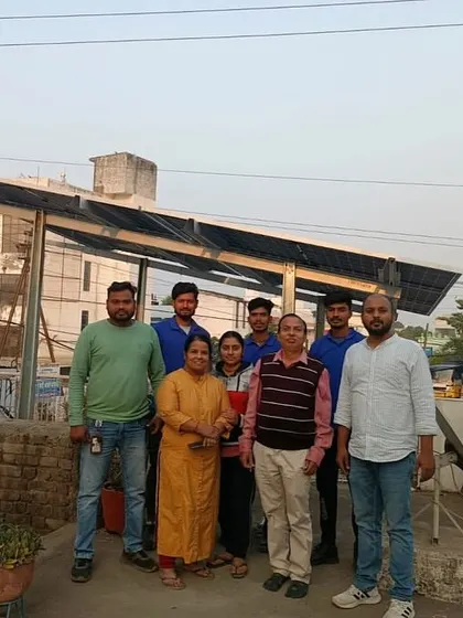 A family poses with our team in front of their newly installed solar system at dusk.