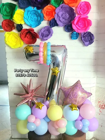 A colorful 7th birthday bouquet with pastel balloons and a paper flower backdrop.