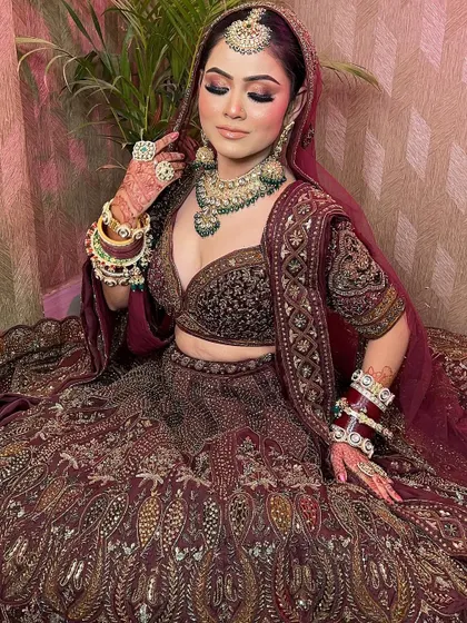 Our bride looks absolutely radiant in this maroon bridal lehenga. The heavy jewelry perfectly complements the intricate work on the outfit.