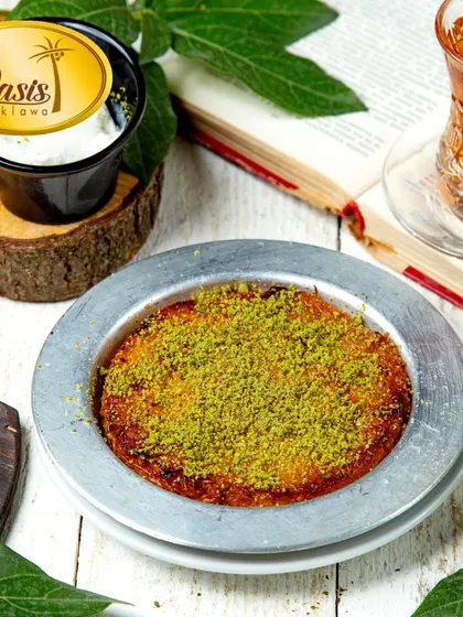 Our authentic Kunafa, served warm with a generous sprinkle of pistachios. This traditional dessert features a creamy, cheesy center and a crispy, golden-brown pastry crust.
