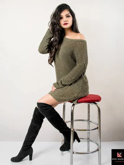 A seated portrait from the 'Attitude on Fleek' shoot. The model's long hair and confident pose on the stool create a powerful and glamorous fashion image.