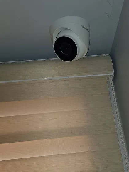 A dome camera mounted in the corner of a ceiling for maximum room coverage.