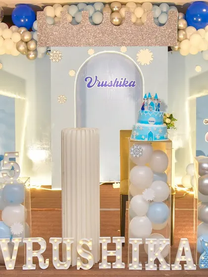 Let it go with a Frozen-themed party. This setup features character cutouts of Elsa and Olaf, a sparkling backdrop, and balloon arrangements in icy blue and silver to create a winter wonderland.
