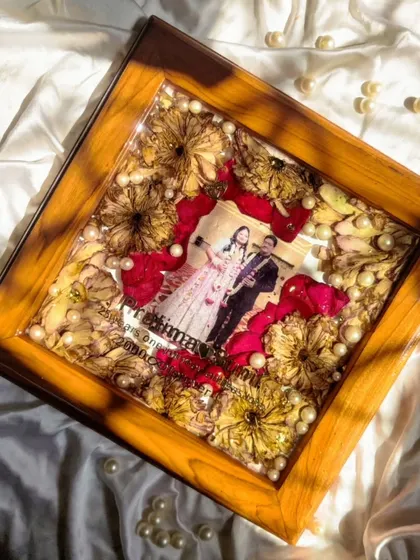This 25th-anniversary frame is a testament to enduring love. The combination of red and yellow roses with pearl accents creates a classic and elegant look.