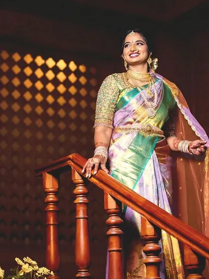 The elegance of a Sumaya bride. Standing on the stairs, her multi-tonal saree drapes beautifully, showcasing the craftsmanship and unique color palette we designed together.