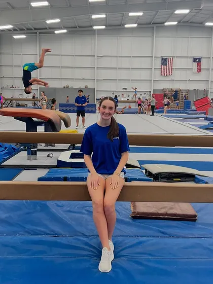 We believe in celebrating our AWESOME team! Here's one of our fantastic coaches, with a student in the background mastering a back handspring on the tumble track. Our coaches are here to guide and support every child through their fitness journey.