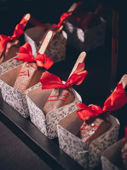 Beautifully packaged cakesicles with red ribbons, perfect as dessert or a party favour.
