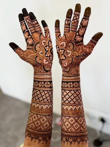 A classic bridal pose, showcasing a design with large mandalas on the palms and geometric patterns on the arms.