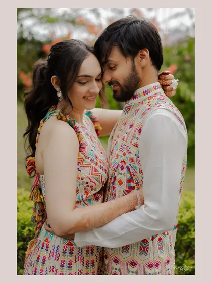 A close-up, intimate portrait of the couple, showcasing their colorful, coordinated outfits and their happy connection.
