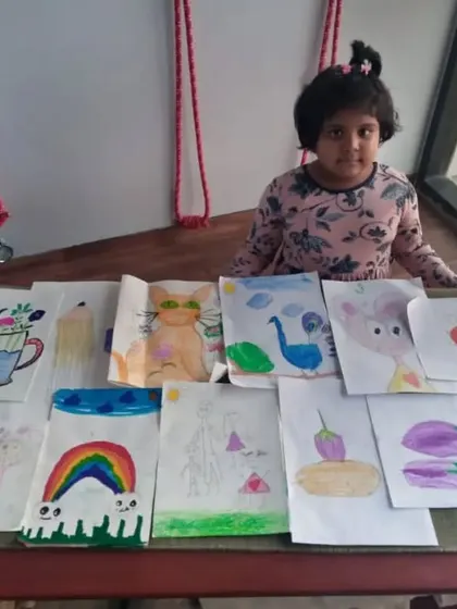 This is Nataniya, one of our 6-year-old students, with a selection of her work. Even at a young age, she has explored everything from rainbows and cartoons to still life drawings of vegetables.