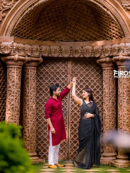 A couple dances in front of the intricately carved wooden doors, a perfect setting for a traditional and elegant pre-wedding photo.