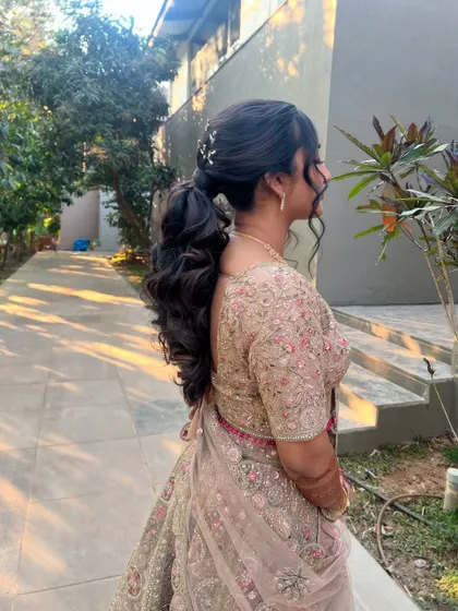 A side profile of the bride with her low ponytail, a chic and comfortable style for a long evening of celebration.