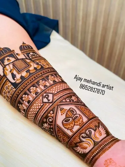 A close-up of a forearm band featuring a royal elephant, dhol drums, and swans, all symbols of a joyous wedding celebration.