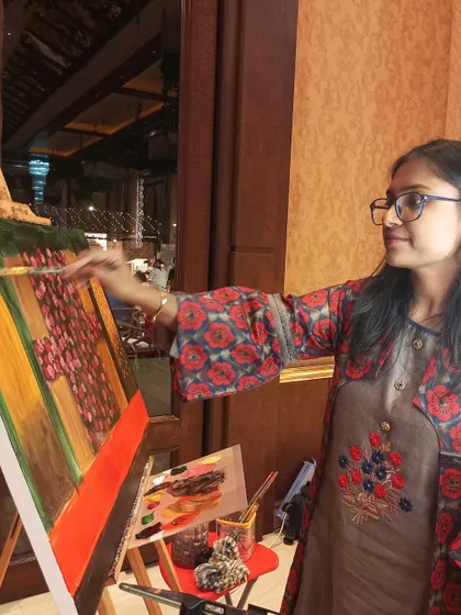 A close-up of me at work. Using a reference photo on my tablet and a palette of acrylics, I carefully paint the details of the couple's portrait during the event.