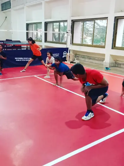 Young players in a ready stance during a fitness drill. This fundamental position is crucial for explosive movement and quick reactions during a match.