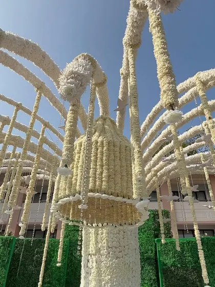 A look up at the 'Kalpavruksh' or wish-fulfilling tree, crafted entirely from white floral strings. This was a unique and symbolic centerpiece for the wedding, representing blessings and prosperity.