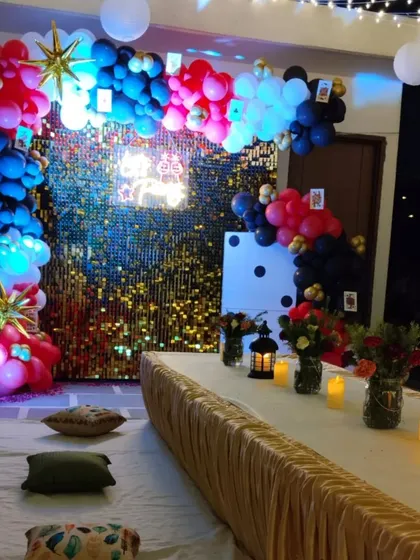 A low-seating arrangement for a Diwali party, set against a modern casino-themed backdrop with lanterns and cushions for a comfortable and festive vibe.