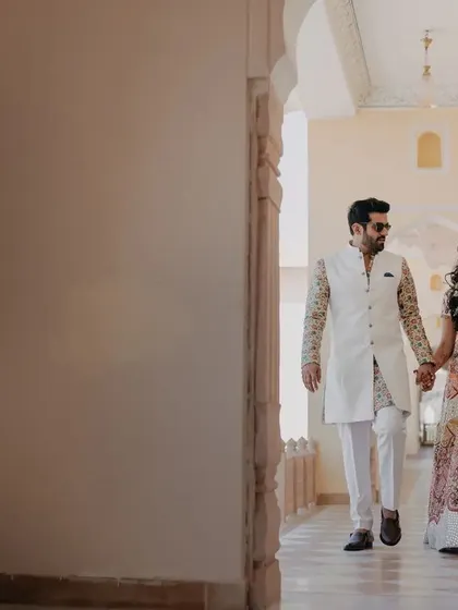 The couple taking a walk through the palace corridors during their wedding festivities. This candid moment captures them in a relaxed and happy state.