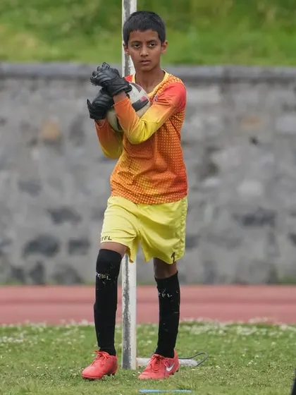 A goalkeeper stands ready and focused, anticipating the next shot during a match in Ooty.